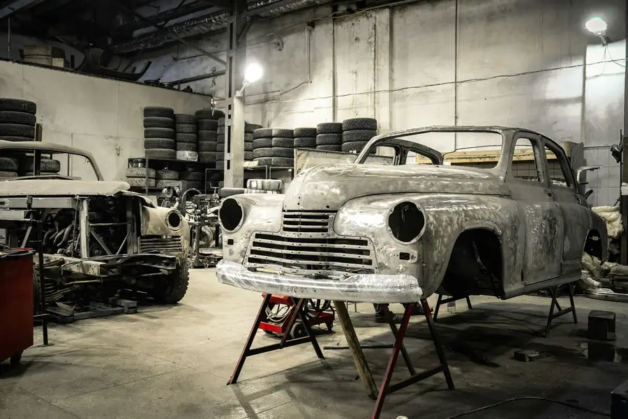 Illustrative photo of bare vehicle bodies on stands in a workshop. Not a Russell's restoration.
